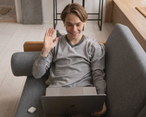Man waving at computer