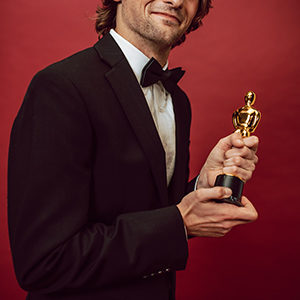 Man in tuxedo holding award